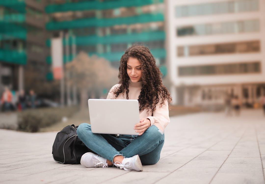 Free Woman in Pink Sweater Using Laptop  Stock Photo