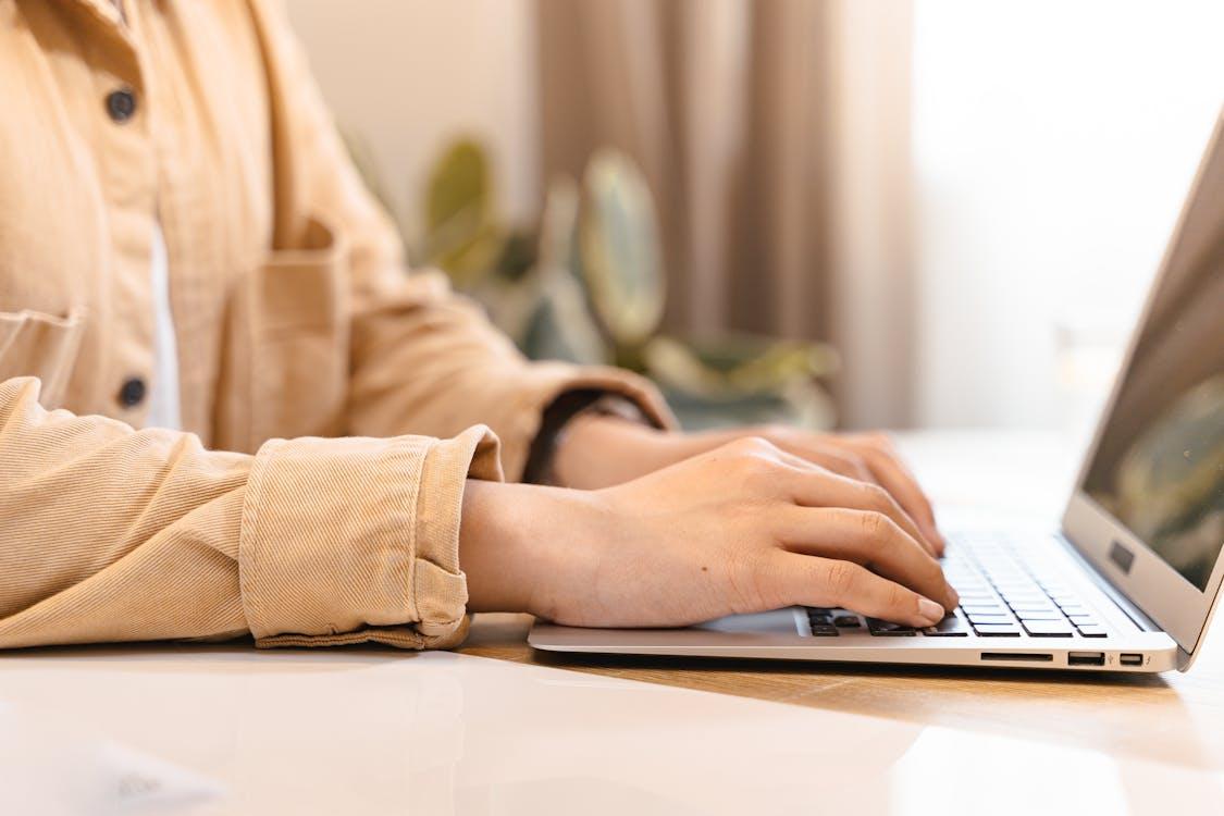 Free A Person Typing on a Laptop Stock Photo