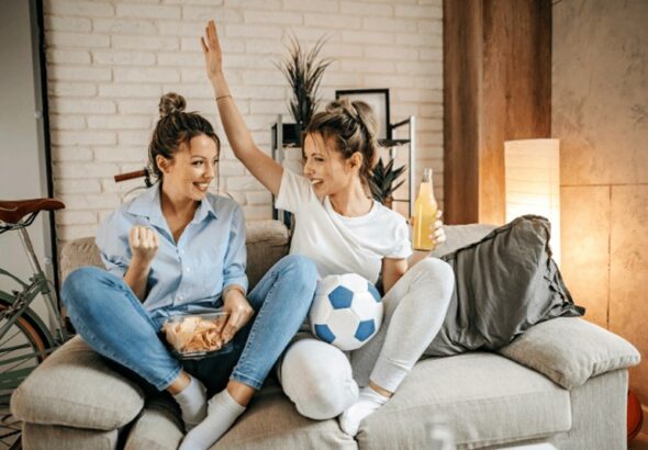 Roommates watching sport on tv, cheering
